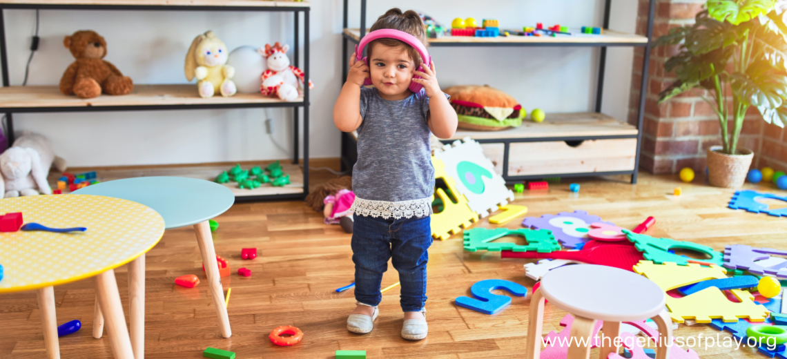 young child wearing headphones in cluttered toy room