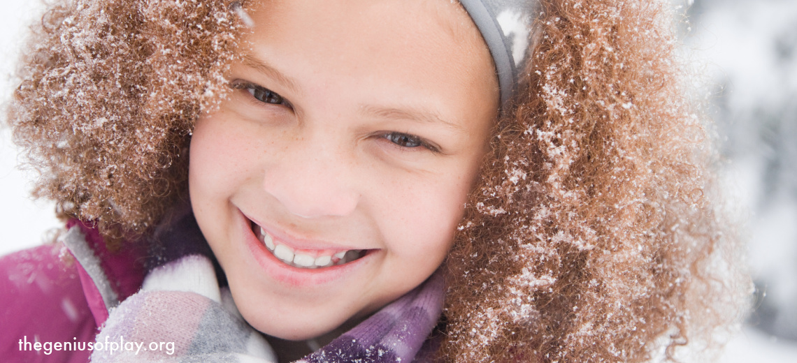 young girl playing outside covered in snowflakes