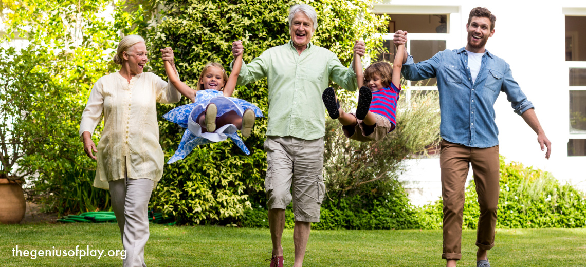 multi-generational family of grandparents, father and children happily playing outdoors 