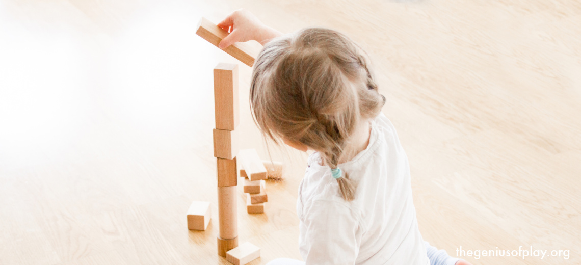 young preschool aged girl playing with building blocks
