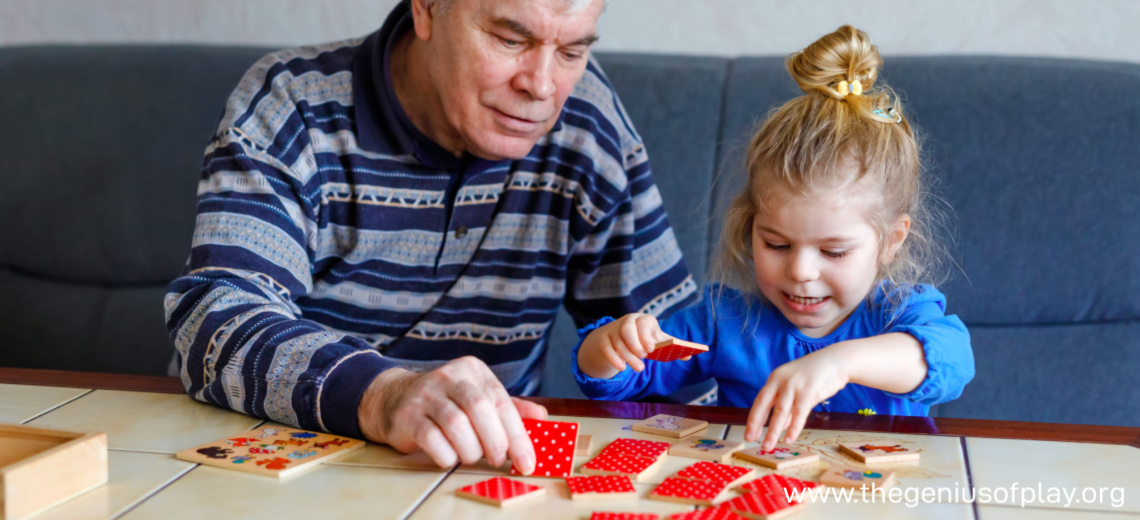 grandfather and toddler granddaughter playing with colored tiles