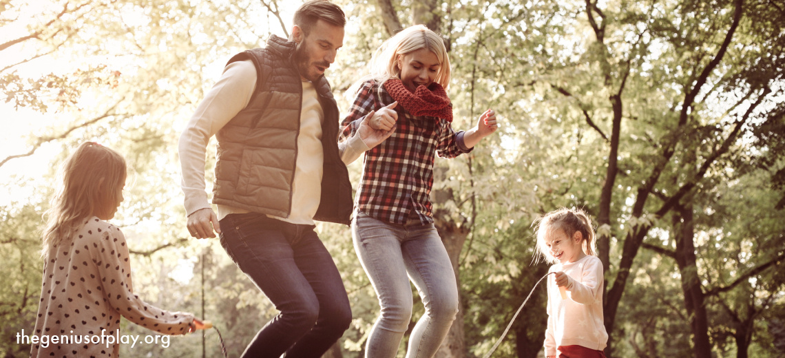 cheerful family jumping rope in the park
