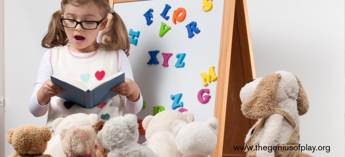young girl playing teacher with magnetic letters and stuffed animals