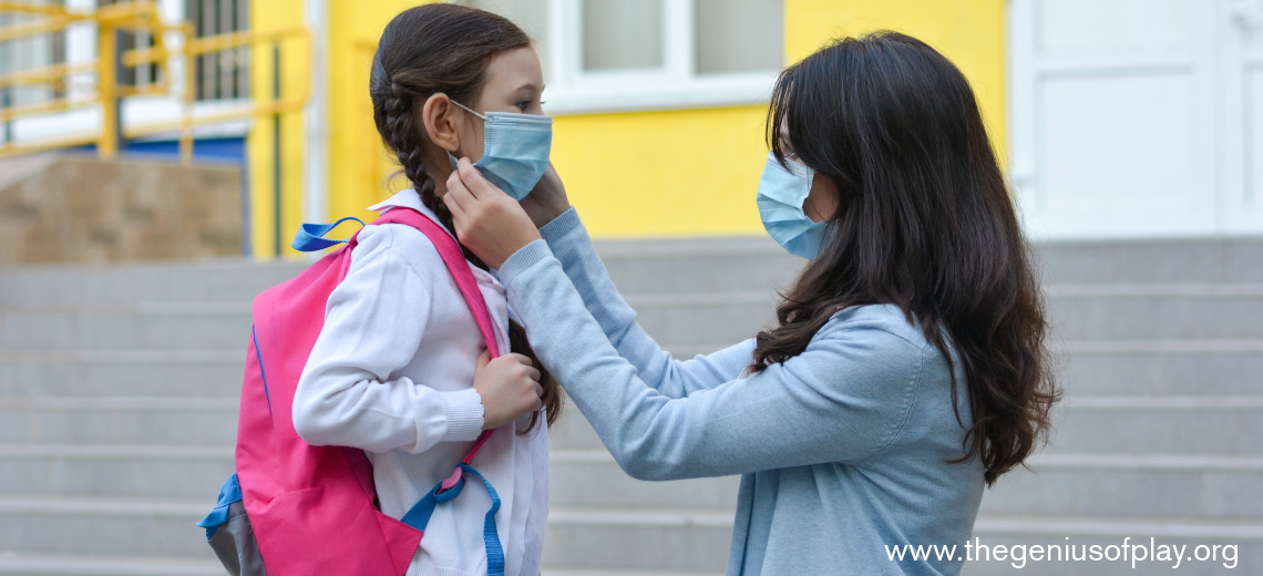 Mom helping young daughter put on a face mask during COVID-19