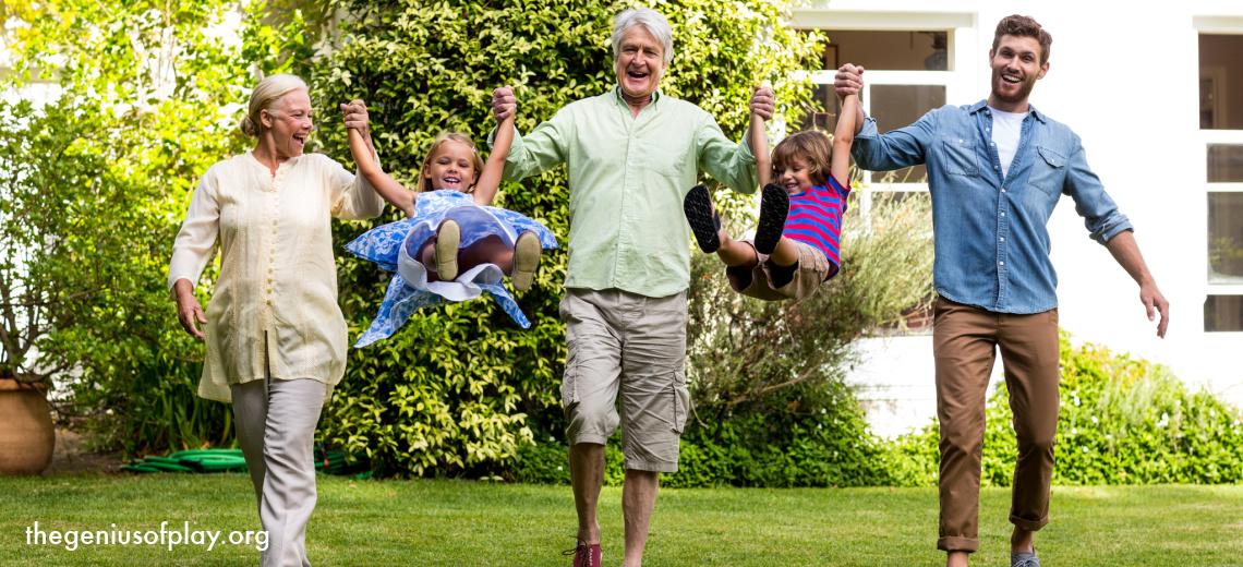multi-generational family of grandparents, father and children happily playing outdoors 